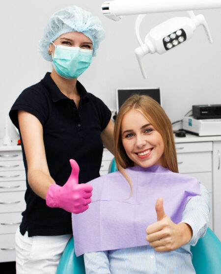 woman-shows-thumb-up-sitting-with-stomatologist-dentist-office woman-shows-thumb-up-sitting-with-stomatologist-dentist-office